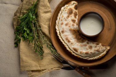 plaka ile ev yapımı pasta, kase ve mutfak eşyaları, otlar asitlendirilmiş krem kopya alanı ile Üstten Görünüm