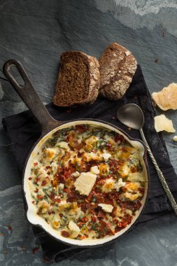 Üstten Görünüm içinde balık pastası peynirli tava ve siyah peçeteye kaşıkla ekmek