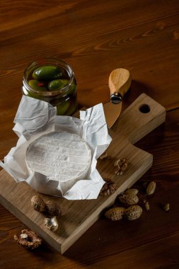 brie peyniri, fındık ve zeytin ve capperi kopya alanı rustik ahşap tablo ile kavanozlar ile düz lay