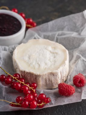 Camembert peyniri taze çilek ile kapatın ve taş karanlık masaya jam