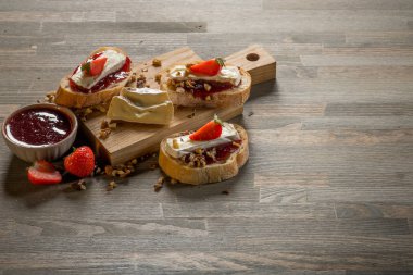 reçel ve çilek, fındık ve kopya alanı ile ahşap masa üzerinde peynir ile lezzetli sandviç ile kase