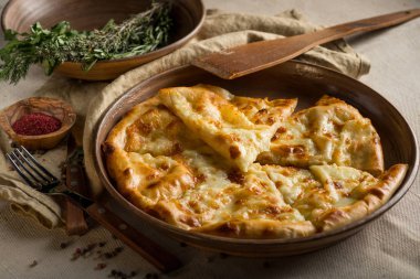 ev yapımı peynir pasta masaya mutfak gereçleri ile dilimlenmiş.