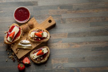 meyve reçeli ve çilek, fındık ve ahşap masa, kopya alanı ile üstten görünüm üzerinde peynir ile lezzetli sandviç ile kase