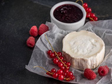 Brie peyniri taze meyveleri ve kopya alanı ile taş karanlık tabloda reçel ile