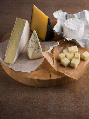 ahşap tahta üzerinde çeşitli peynir dilimleri