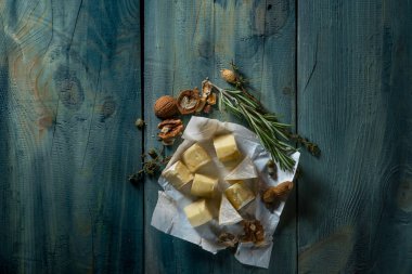 Brie peyniri dilimleri, otlar ve fındık mavi ahşap arka plan, kopya alanı ile Üstten Görünüm