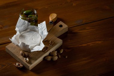brie peyniri, fındık ve zeytin ve capperi kopya alanı rustik ahşap tablo ile kavanozlar ile düz lay