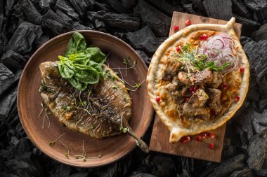 Balık ve otlar ve et ve kömür pişirme baharatlar ile ev yapımı ekmek ile plaka