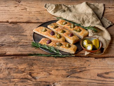 pasta dilimi zeytin, biberiye ve ahşap masa kopya alanı ile kase biber dolması ile