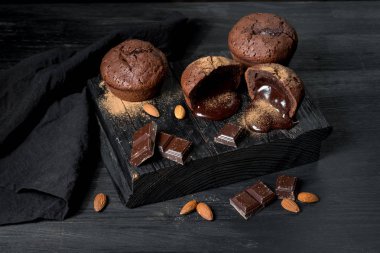 tatlı lav kek, badem ve çikolata parçaları peçete ile siyah ahşap tahta üzerinde