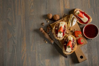 meyve reçeli ve çilek, fındık ve ahşap masa, kopya alanı ile üstten görünüm üzerinde peynir ile lezzetli sandviç ile kase