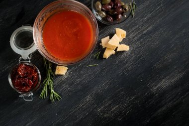 kopya alanı siyah ahşap zemin üzerine salam, zeytin, peynir ve domates sosunun Üstten Görünüm