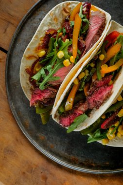 En çok lezzetli tacos görünümünü ahşap arka plan üzerinde siyah plaka üzerinde yakın çekim