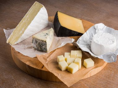 rustik düz lay ahşap tahta üzerinde çeşitli peynir dilimleri ile