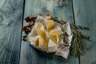 Brie peyniri dilimleri, otlar ve fındık mavi ahşap arka plan, kopya alanı ile Üstten Görünüm