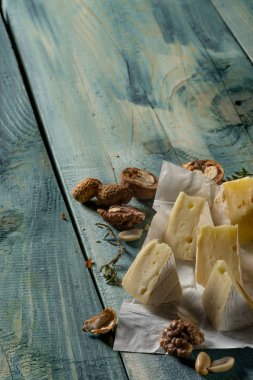 Camembert peyniri dilimleri ve fındık mavi ahşap arka plan, kopya alanı ile Üstten Görünüm