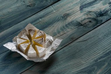 rustik düz lay mavi ahşap arka plan, kopya alanı ile üstten görünüm dilimlenmiş brie peyniri ile