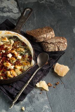 Üstten Görünüm içinde balık pastası peynirli tava ve siyah peçeteye kaşıkla ekmek
