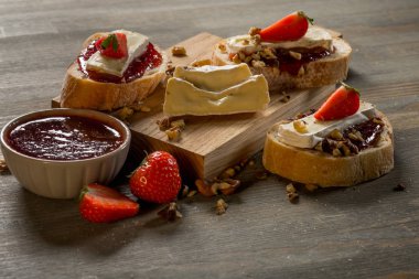 reçel ile kase ve çilek, fındık ve ahşap tahta üzerinde peynir ile lezzetli sandviçler yakın çekim