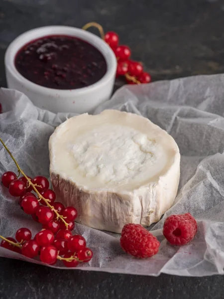 Camembert peyniri taze çilek ile kapatın ve taş karanlık masaya jam