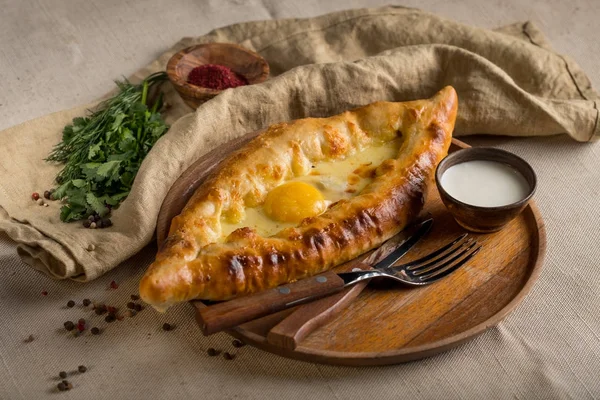 ev yapımı khachapuri, krema, çatal ve bıçak rustik bez, üstten görünüm üzerinde bir kase ile Tablo ayarı 