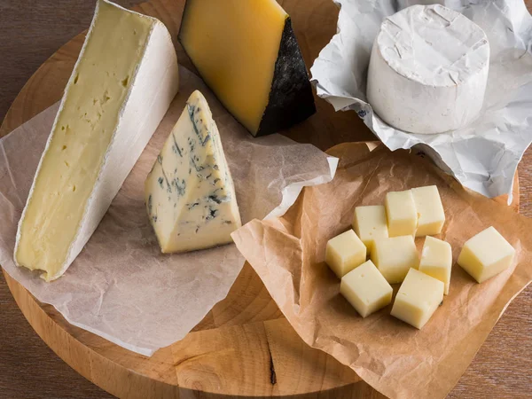 Ahşap Tahta Üzerinde Çeşitli Peynir Dilimleri — Stok fotoğraf