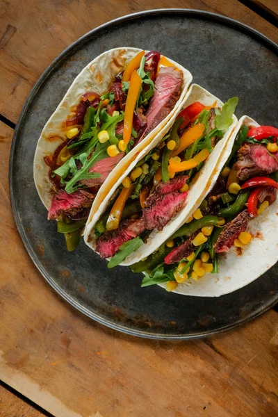 Draufsicht Auf Leckere Tacos Auf Schwarzem Teller Auf Hölzernem Hintergrund — Stockfoto