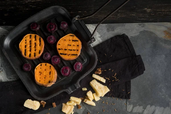 grilled pumpkin and beetroot slices on frying pan with cheese