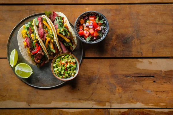 Köstliche Tacos Mit Limettenscheiben Und Geschnittenem Gemüse Schüsseln Auf Holzhintergrund — Stockfoto