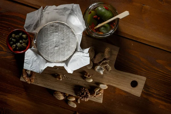 Deitado Com Queijo Brie Faca Ervas Frascos Com Azeitonas Capperi — Fotografia de Stock