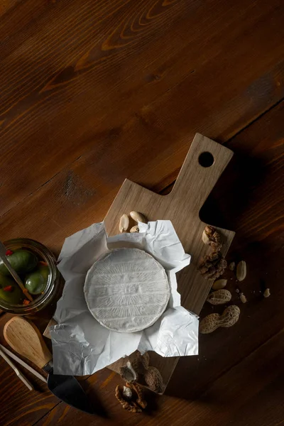 brie peyniri, fındık ve zeytin ve capperi kopya alanı rustik ahşap tablo ile kavanozlar ile düz lay