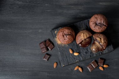 tatlı lav kek, badem ve çikolata parçaları üzerinde siyah ahşap masa, kopya alanı ile Üstten Görünüm