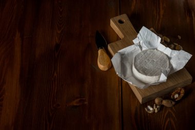Brie peyniri ahşap kesme tahtası ile fındık ve bıçak, kopya alanı ile Üstten Görünüm