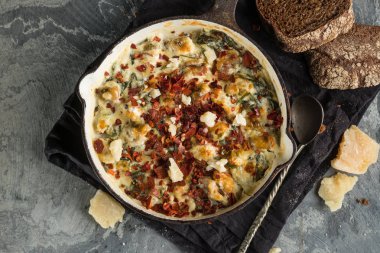 Üstten Görünüm içinde balık pastası peynirli tava ve siyah peçeteye kaşıkla ekmek