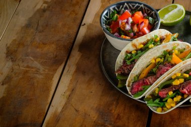 limon dilimleri ve ahşap masa üzerinde kaseler, kopya alanı ile üst görünüm kesilmiş sebzeler ile baharatlı tacos