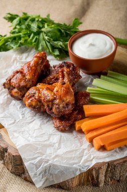 Buffalo kanatlar sebze dilimleri ile rustik arka plan üzerinde tavuk