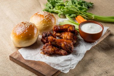 Buffalo kanat tavuk ve topuz ile susam ahşap tahta üzerinde peynir sosu ve kereviz ve havuç ile sopa görev yaptı. Üstten Görünüm