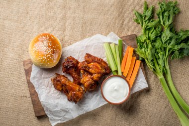 Buffalo kanat tavuk ve topuz ile susam ahşap tahta üzerinde peynir sosu ve kereviz ve havuç ile sopa görev yaptı. Üstten Görünüm