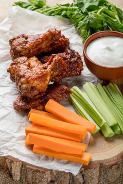 Buffalo kanatlar sebze dilimleri ile rustik arka plan üzerinde tavuk