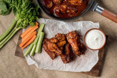 Sebze çubukları ve peynir soslu beyaz masada Buffalo tavuk