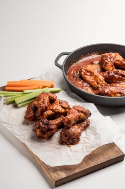 Buffalo kanatları beyaz masada sebze sopa ile servis tavuk