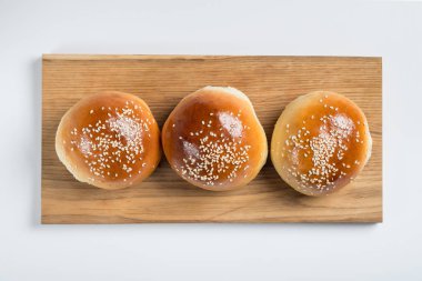 Burger ekmek buns ahşap masa beyaz izole arka planda, üstten görünüm 