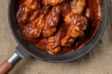 demir tavada kırmızı soslu kızarmış tavuk görünümünü kapat