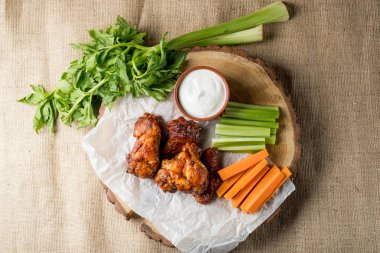 Buffalo kanatlar sebze dilimleri ile rustik arka plan üzerinde tavuk