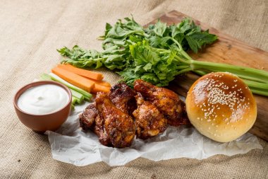 Buffalo kanat tavuk ve topuz ile susam ahşap tahta üzerinde peynir sosu ve kereviz ve havuç ile servis sopa