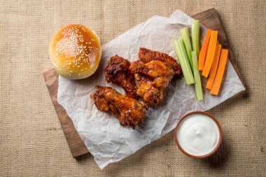 Buffalo kanat tavuk ve topuz ile susam ahşap tahta üzerinde peynir sosu ve kereviz ve havuç ile sopa görev yaptı. Üstten Görünüm