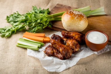 Buffalo kanat tavuk ve topuz ile susam ahşap tahta üzerinde peynir sosu ve kereviz ve havuç ile servis sopa