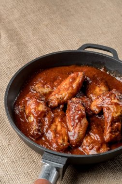 demir tavada kırmızı soslu kızarmış tavuk görünümünü kapat