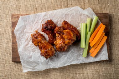 Buffalo kanatlar sebze dilimleri ile rustik arka plan üzerinde tavuk