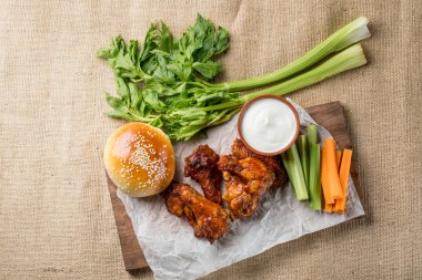 Buffalo kanat tavuk ve topuz ile susam ahşap tahta üzerinde peynir sosu ve kereviz ve havuç ile sopa görev yaptı. Üstten Görünüm